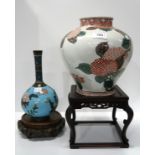 A Cloisonne bottle vase on wooden stand and a Chinese pottery vase decorated with Hydrangeas, on