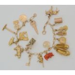 A 9ct charm bracelet with thirteen 9ct gold charms, four in yellow metal to include a monkey holding
