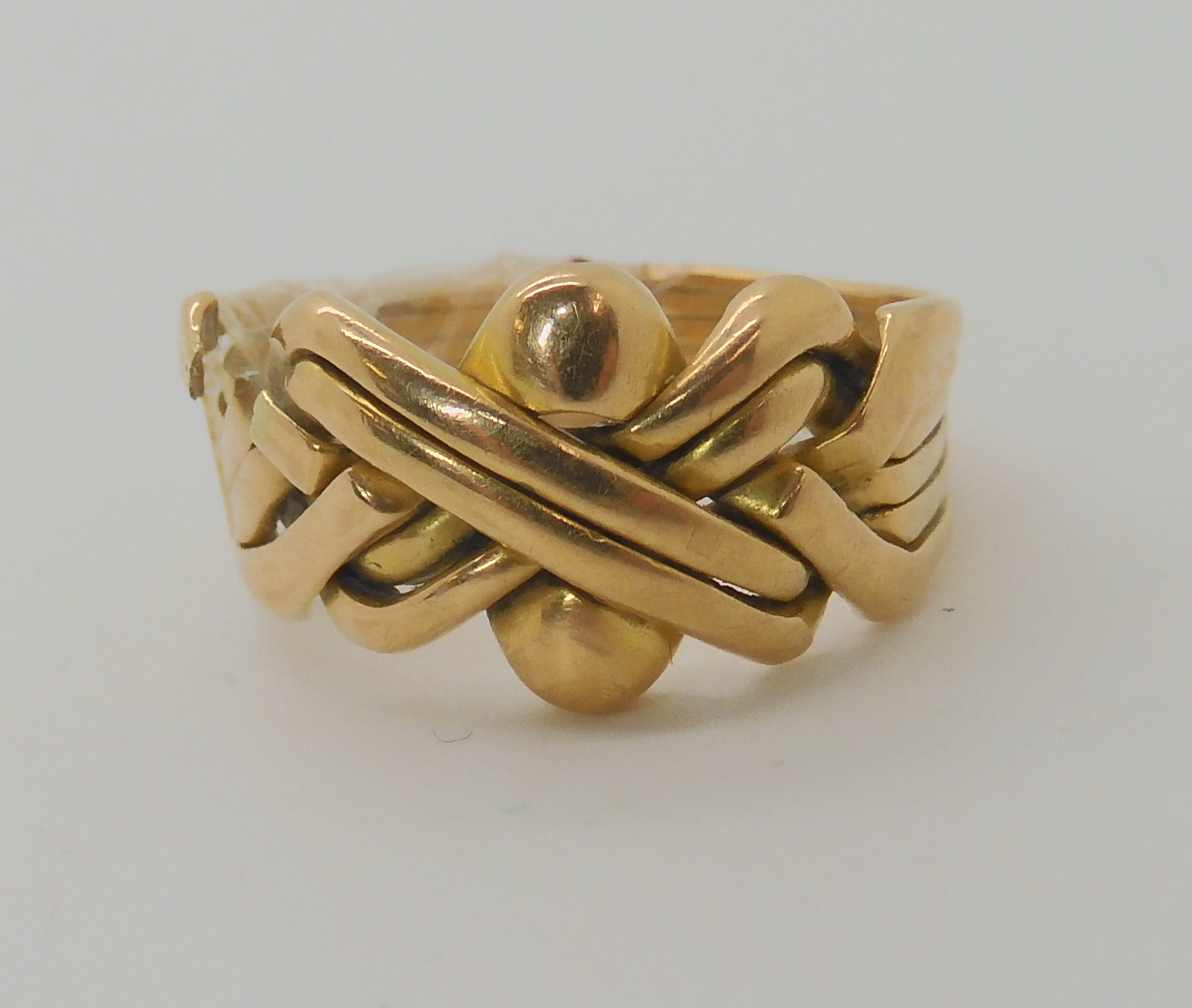A bright yellow metal puzzle ring, weight 10.9gms Condition Report: The ring is selotaped together