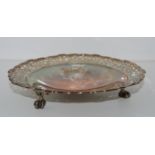 A silver dish, Birmingham 1912, circular with pierced rim on three claw and ball feet, 19.5cm