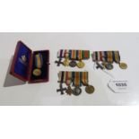 A lot comprising three miniature Military Cross groups of four & a cased 1902 miniature Victory