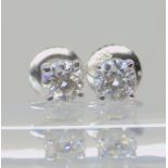A pair of classic 14k white gold diamond ear studs with safety screw post fittings, set with