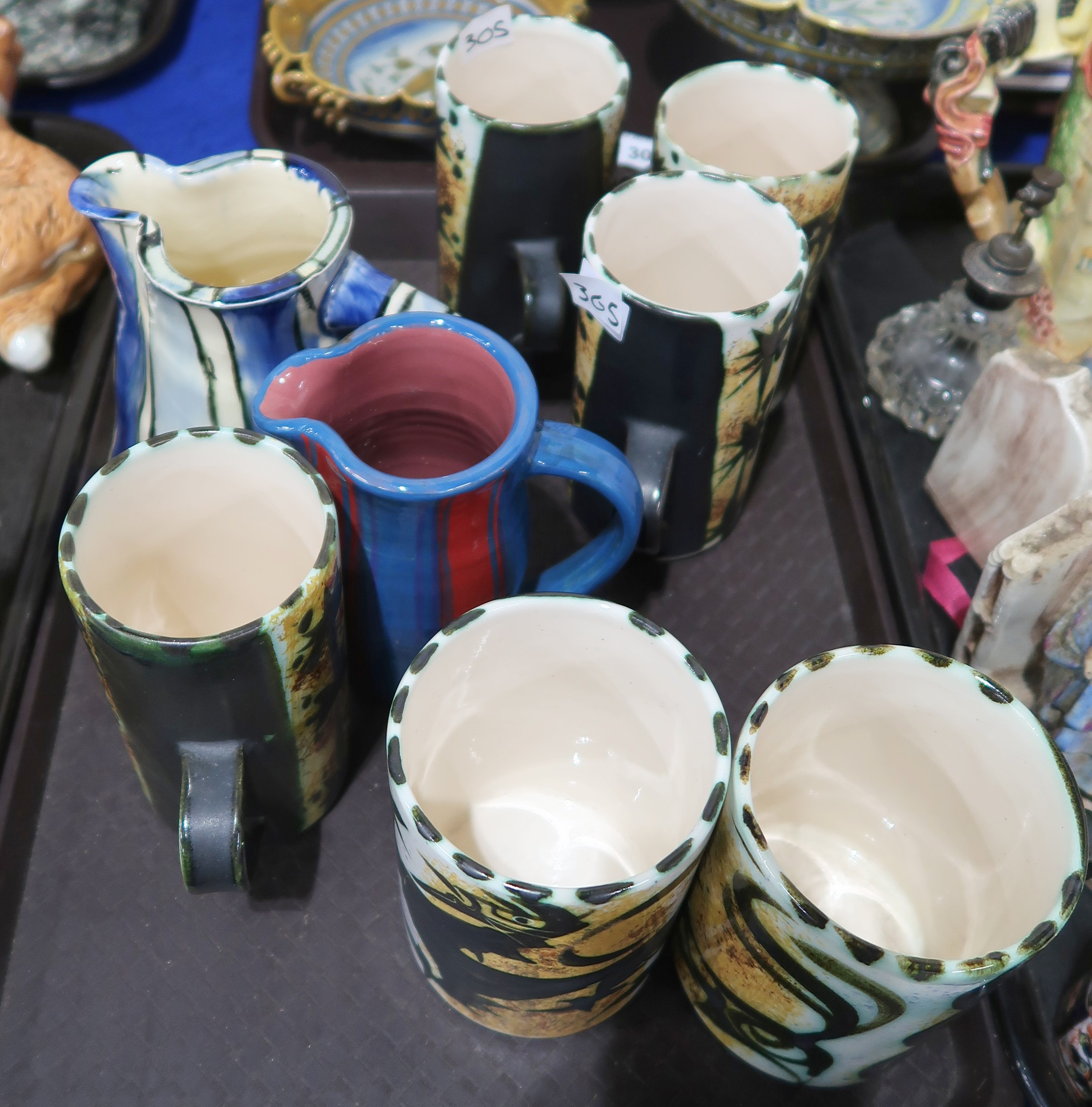 a selection of Newlyn celtic pottery cups, two studio pottery jugs Condition Report: Not available