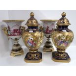 A pair of French puce painted urns with applied floral decoration upon gilded bases and a pair of