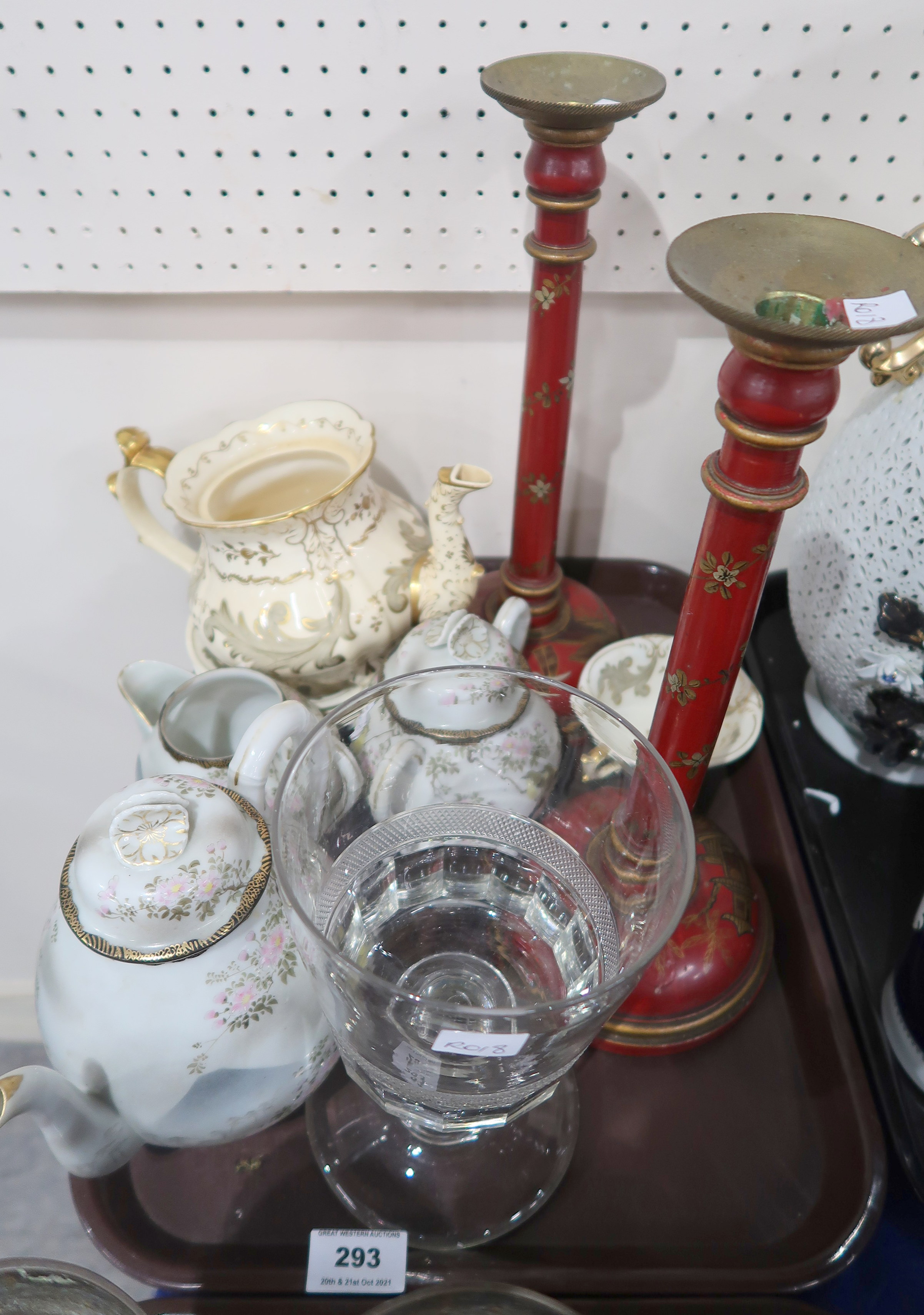 A pair of red ground wooden gilt painted candle sticks, a cut glass goblet, a Rockingham teapot, cup