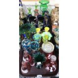 A selection of coloured glass including cranberry Mary Gregory style decanters, bells, biscuit