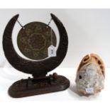 An Indian carved wooden and brass table gong and a carved cameo shell light shade Condition