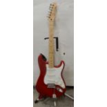 A Fender Stratocaster in candy apple red and white scratch plate, made in Mexico serial number
