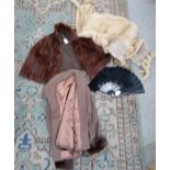 A pale fur stole, a brown fur shrug, a ladies brown jacket with fur trimmed cuffs, a black feather