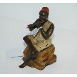 A cold-painted inkwell modelled as seated Arab man with hinged top, 12cm high Condition Report: