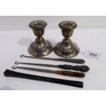 A lot comprising a pair of silver candlesticks, London 1928, 7.5 cm high, three buttonhooks & a