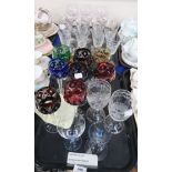 A set of cased coloured cut glass drinking glasses, a set of gilt rimmed glasses, and another set of