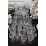 A collection of cut glass and crystal drinking glasses, some with frosted decoration, an EPNS topped