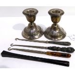 A lot comprising a pair of silver candlesticks, London 1928, 7.5 cm high, three buttonhooks & a
