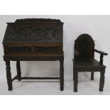 A CHINESE CARVED WOOD WRITING BUREAU with dragon rail above a hinged door carved with figures in a