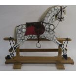 A ROCKING HORSE (20TH CENTURY) the painted pine body with dappled colour, set with leather saddle
