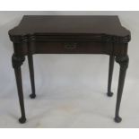 A GEORGIAN MAHOGANY TRIPLE TOP CARD TABLE the shaped top enclosing a baize interior and carved