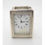 AN EDWARDIAN SILVER MINUET CARRIAGE CLOCK, the circular white enamelled dial with Roman numerals,