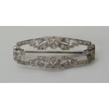 AN ART DECO DIAMOND SET BROOCH mounted in white metal and set with estimated approx 0.80cts of old
