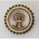 A GEORGIAN SHEAF OF WHEAT MOURNING BROOCH the hair art is mounted on a mother of pearl rondel with a