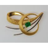 A BRIGHT YELLOW AND WHITE METAL EMERALD BROOCH set with a step cut emerald of approx 5.3mm x 4.3mm x
