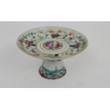 A CHINESE STEMMED DISH painted with peaches and lilies above waves, gilt rim, 8cm high and 13.8cm