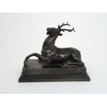 BRONZE OF A STAG modelled lying down, upon rectangular plinth, scratch signature to side, 14.5cm