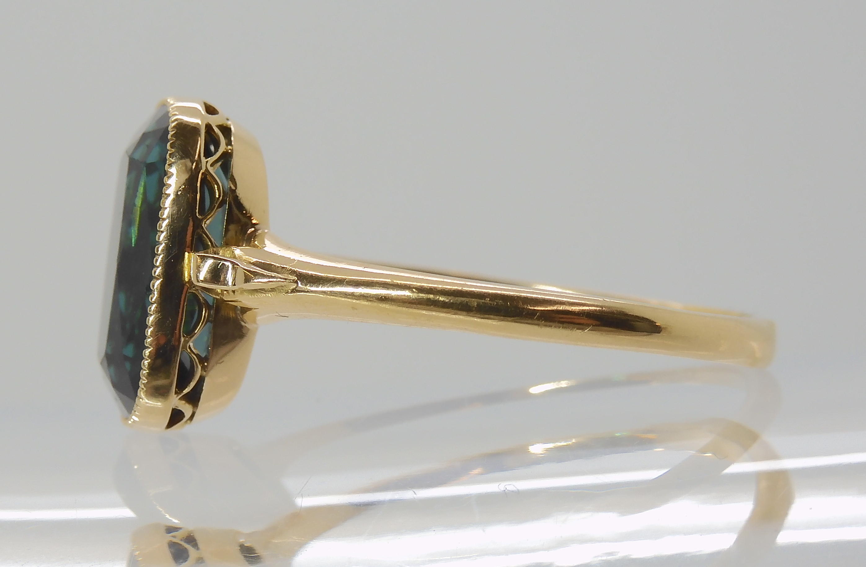 A TEAL COLOURED TOURMALINE RING mounted in bright yellow metal, with decorative scroll shoulders, - Image 4 of 4