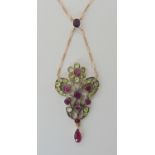 AN EDWARDIAN STYLE PENDANT NECKLACE set with rubies and green gems. Length of pendant 4.8cm, and