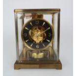 A JAEGER LE COULTRE ATMOS CLOCK the brass and silvered case with five glass panels, the black dial