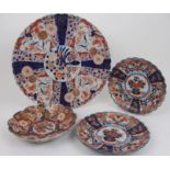 A LARGE IMARI LOBED DISH painted with panels of flowers, 46.5cm diameter and three smaller dishes,