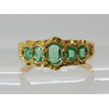 AN 18CT GOLD VICTORIAN STYLE EMERALD RING the five bright and lively emeralds are set in a classic