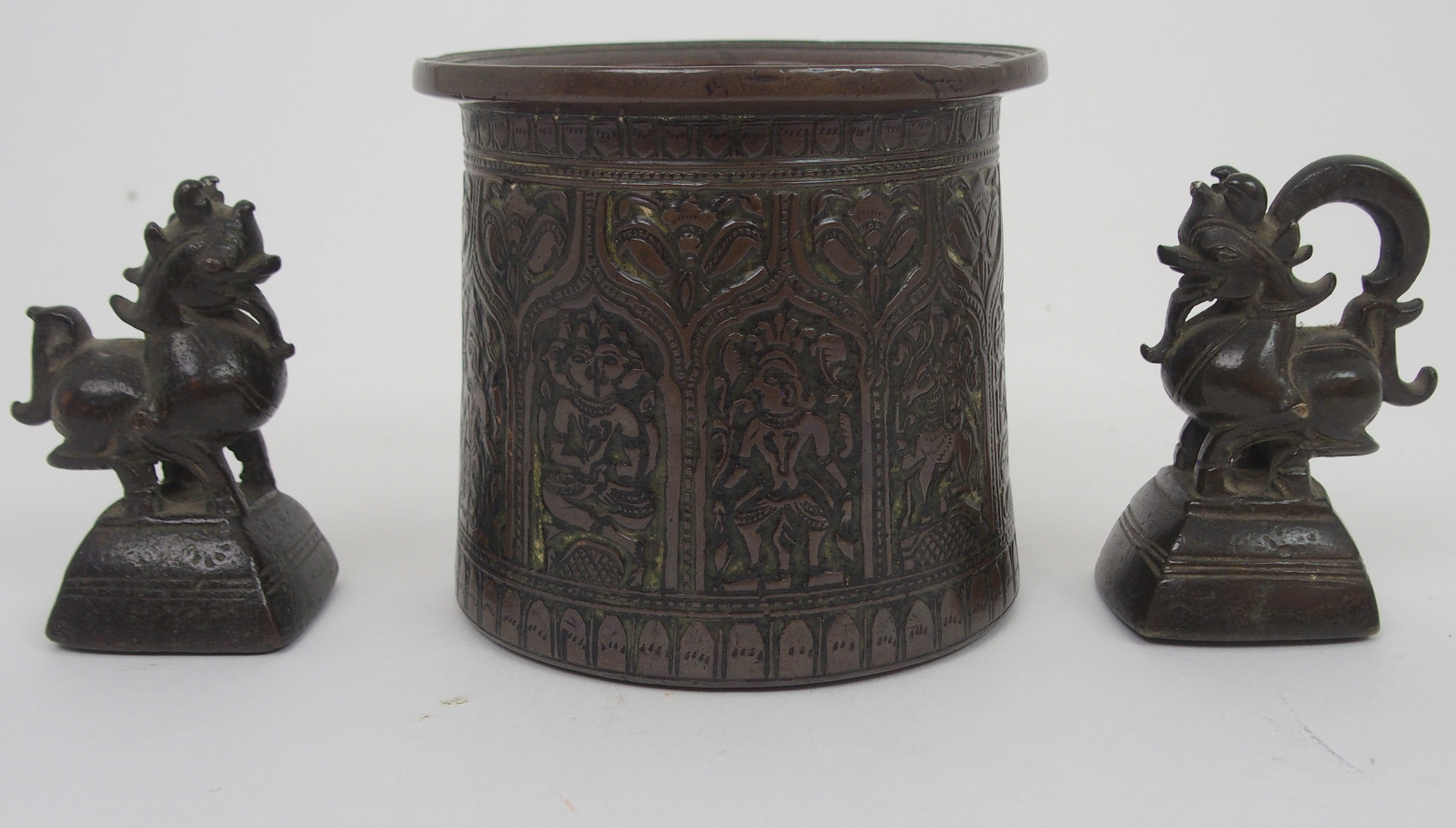 AN INDIAN BRONZE VASE cast with panels of deities within arched niches and within stiff leaf