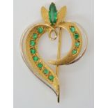AN 18CT GOLD EMERALD RETRO BROOCH in a stylised heart shape, set with good quality emeralds.