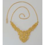 A BRIGHT YELLOW METAL INDIAN PIERCED DETAIL NECKLET dimensions of the front 'V' element 10.3cm