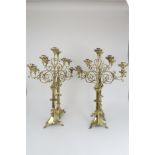 A SET OF FOUR LARGE BRASS ECCLESIASTICAL CANDELABRA each with scrolling arms and five candle