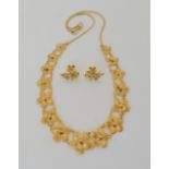 AN INDIAN BRIGHT YELLOW METAL FLOWER MOTIF NECKLET AND EARRINGS length of necklace 40.5cm, length of