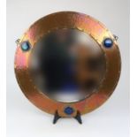 A LARGE ARTS AND CRAFTS CIRCULAR COPPER FRAMED MIRROR with three Ruskin style glazed roundels,