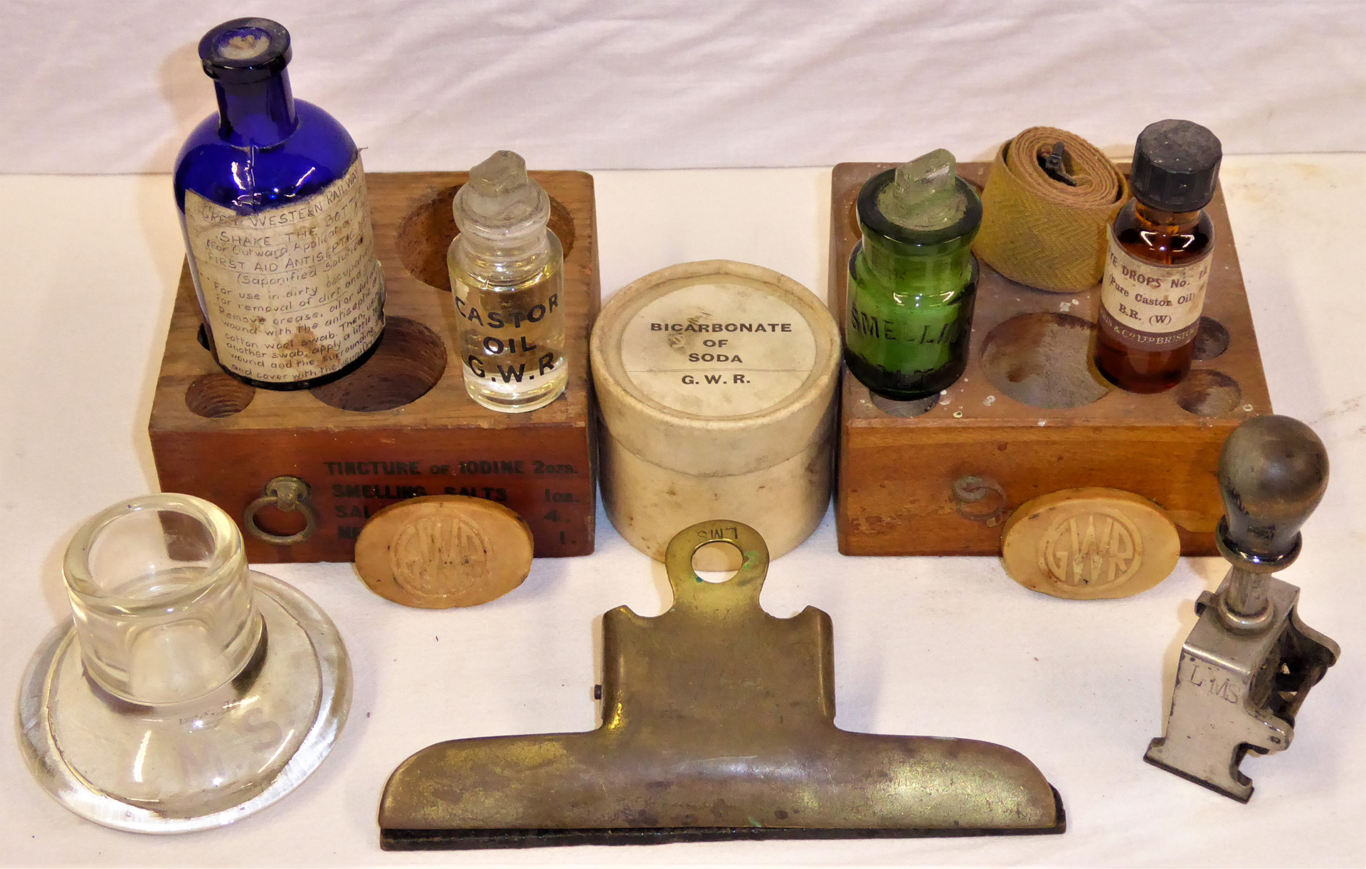 A lot containing railway station items to include LMS brass letter clip. LMS glass ink well. LMS
