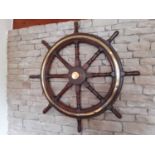 A brass bound teak ship's wheel, with wall fixing bracket and brass center cap, 94cm dia.