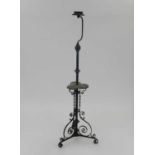 An Edwardian wrought iron lamp standard, the knopped stem with central trefoil wood tier, raised