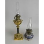 A brass candlestick oil lamp and another earthenware example. (2)
