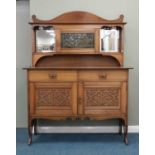 A late 19th century arts and crafts influence oak mirror-back sideboard, the scroll cresting above