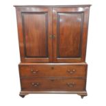 An early 19th century mahogany linen press, the moulded top above twin panelled doors opening to