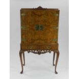 A Queen Anne style walnut cocktail cabinet, mid 20th century, the scroll cresting above twin cabinet