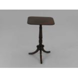 A Regency style mahogany tripod occasional table, the square top above a turned column raised on