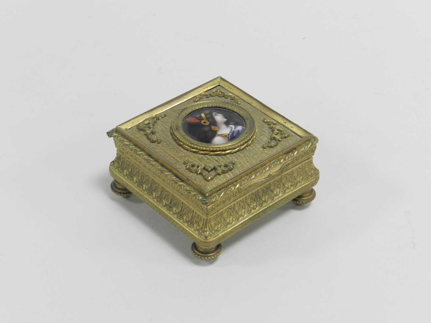 A 19th century French gilt metal jewellery box, the cover inset with an enamel bust portrait of a