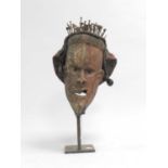 A collection of African and East Asian tribal masks, some with painted decoration, together with a