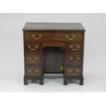 A George III style mahogany kneehole desk, the moulded top above a frieze drawer and six further