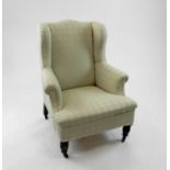 A late Victorian mahogany framed upholstered wing armchair, with recent cream brocade fabric, the